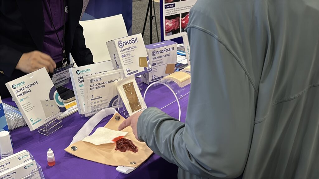 A visitor engaging with Conkote wound care products at SAWC Spring 2025