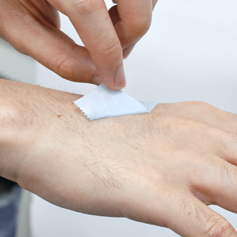 Close-up of Kind Removal Tape edge peeled to show soft silicone adhesive