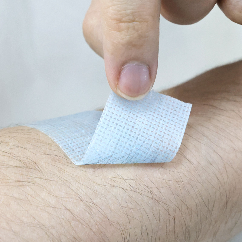 Blue Kind Removal Tape being lifted from skin cleanly with no sticky residue