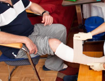 Caregiver gently applying wound dressing at home in a bright and comfortable environment